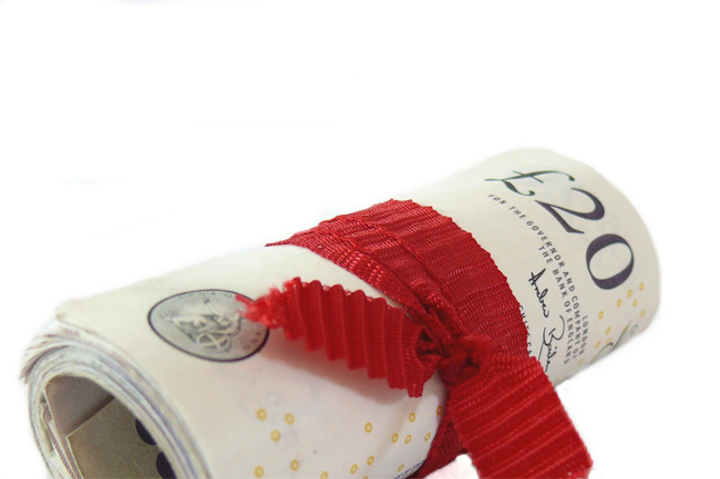 Rolled £20 banknote tied with a red ribbon.