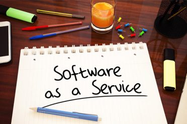 Notebook with ‘Software as a Service’ written on it on a desk.