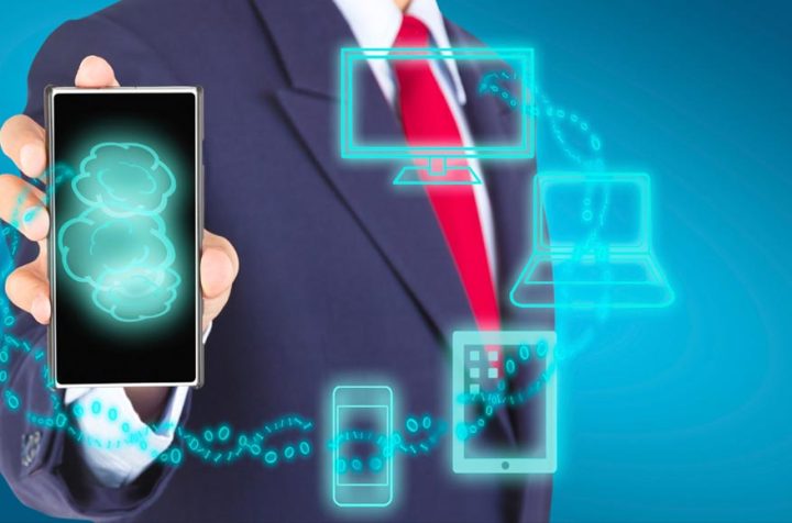Businessman holding a phone displaying a cloud and other devices.