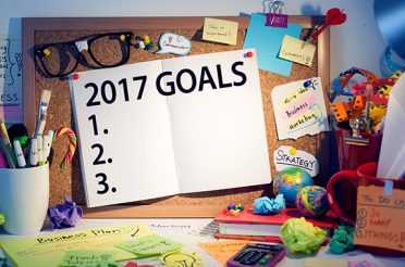 Work desk with a 2017 goal board and notes.