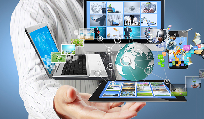 Person holding a computer, laptop, tablet, and phone in their hands.