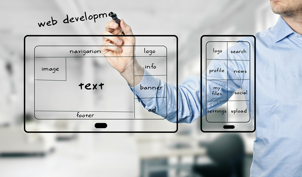 Man drawing a website layout on a tablet and phone.