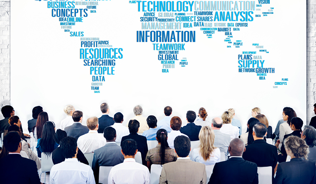 People at a business conference looking at a world map made of words.