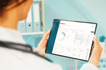 Medical professional reviewing data on a tablet with a dashboard.