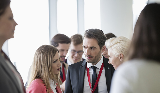 Group of business professionals at an event, talking to each other.