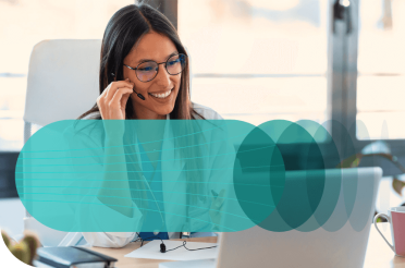 Smiling female doctor with a headset working on a laptop.