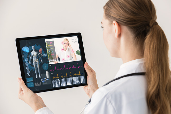 Doctor holding a tablet with holographic patient information.