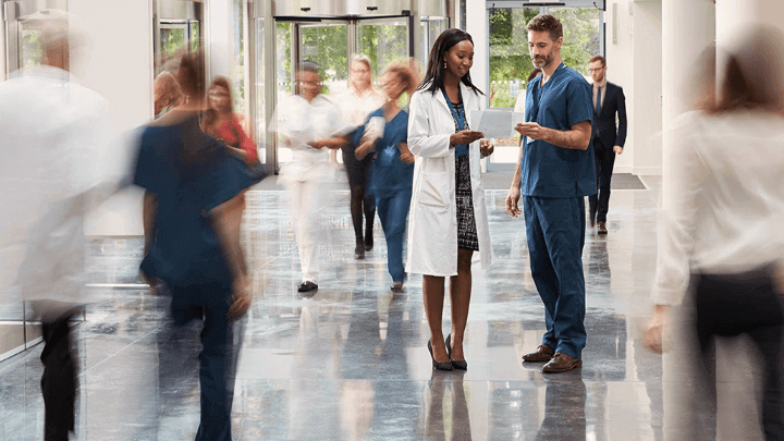 Medical professionals talking in a hospital corridor.