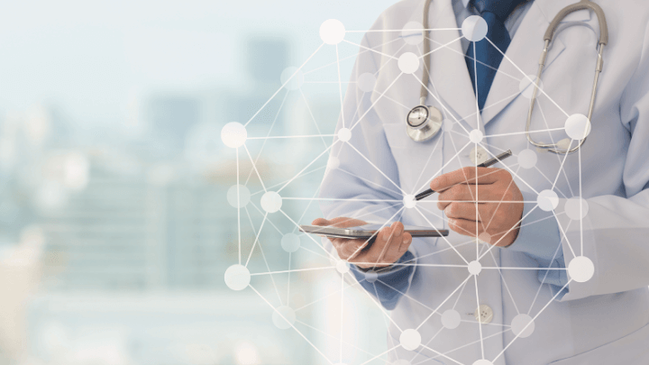 Doctor holding a smartphone and pen, connected to a data network.