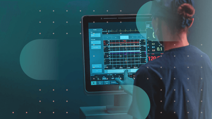 Medical professional reviewing vital signs data on a monitor.