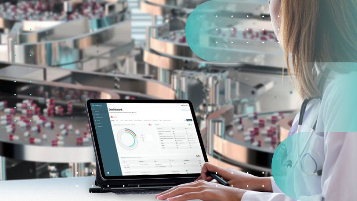 Medical professional reviewing data on a tablet in a factory.