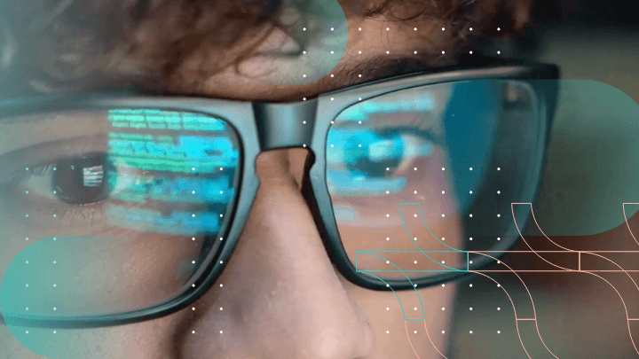 Close-up of a programmer’s eyes reflecting code on the monitor.