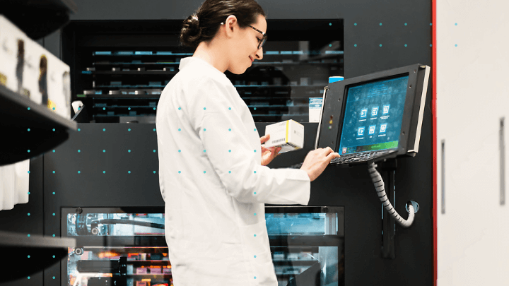 Pharmacist working with an automated medication dispensing system.