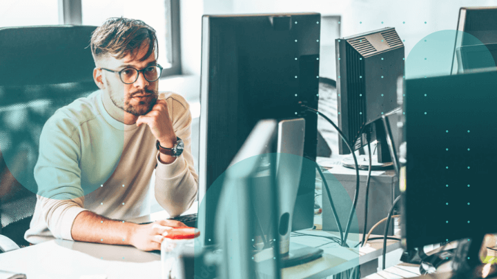 Man wearing headphones working on a computer in an office.