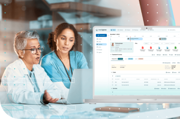 Two doctors reviewing medical data on a laptop.