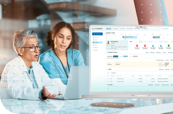 Two doctors reviewing medical data on a laptop.