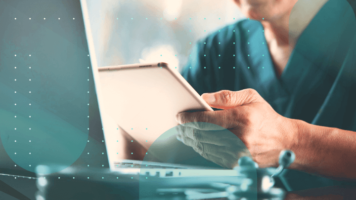 Medical professional working on a tablet and laptop.