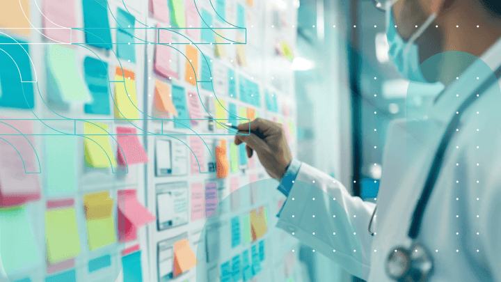 Doctor using sticky notes on a whiteboard for planning.