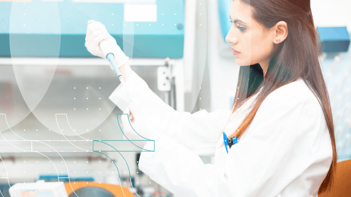 Lab technician in a white coat using a pipette in a laboratory.