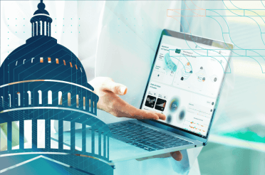 Professional showing data on a laptop, with the Capitol building in the foreground.