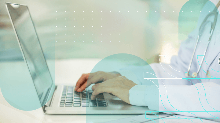 Healthcare professional working on a laptop, entering data.