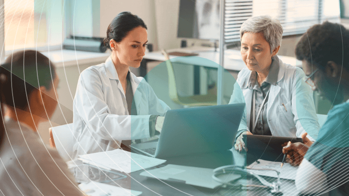 Group of doctors discussing information on a laptop.