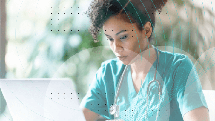 Medical professional focused while working on a laptop.