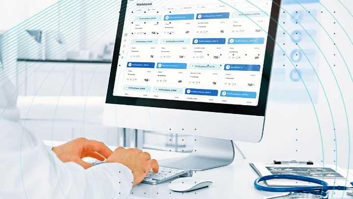 Doctor working on a computer, with task management software visible on the screen.