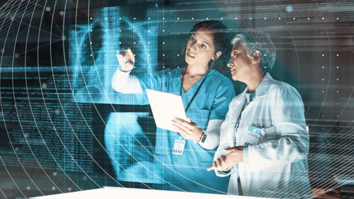 Two female doctors reviewing and discussing a digital X-ray.