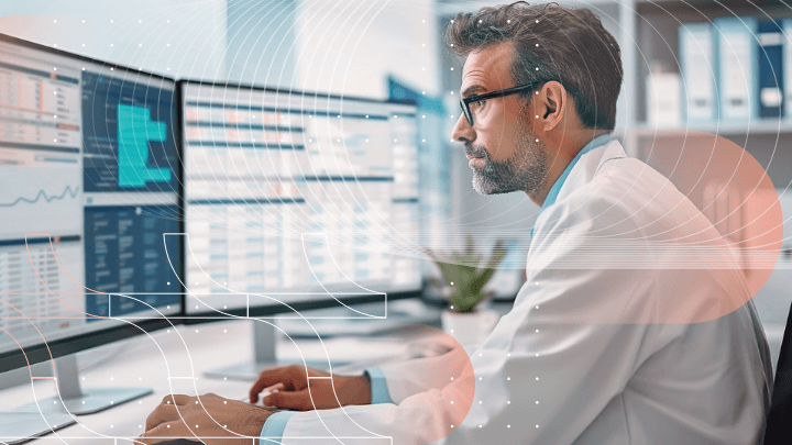 A doctor working with two monitors, analyzing medical data.