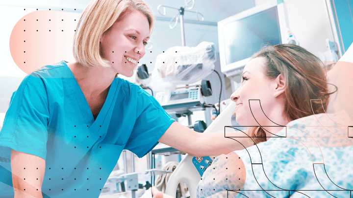 Medical professional smiling and talking to a patient in a hospital bed.