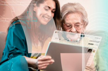 Young woman helping an elderly woman use a tablet
