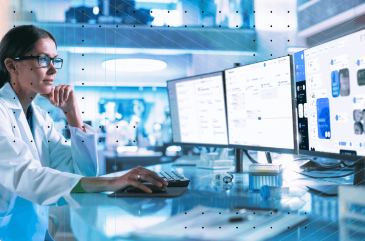 Doctor working on a computer with multiple monitors displaying medical data.