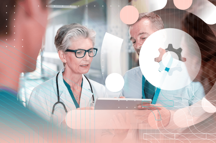 A man and a woman in white coats with stethoscopes looking at a tablet.