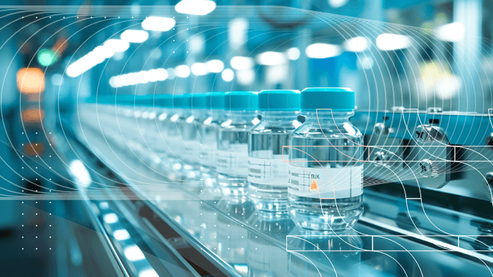 Row of medicine vials moving along a conveyor in a modern manufacturing facility.