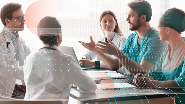 Medical specialists discussing a case during a meeting, seated around a table.